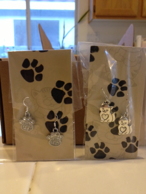 Earrings have cat or dog face charms.